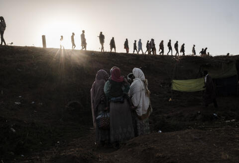 Internally Displaced People (IDP), fleeing from violence in the Metekel zone in Western Ethiopia, walk on a route as others stand below in a camp in Chagni, Ethiopia, on January 28, 2021. - Inter-ethnic violence in Ethiopia's west -- concentrated in a lowland area known as Metekel -- predates a brutal three-month-old conflict farther north pitting Prime Minister Abiy Ahmed's government against the former ruling party of the Tigray region. (Photo by EDUARDO SOTERAS / AFP)