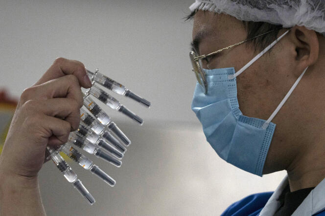 Un employé inspecte les seringues d’un vaccin contre le Covid-19 produit par le laboratoire Sinovac, dans son usine de Pékin, le 24 septembre 2020.