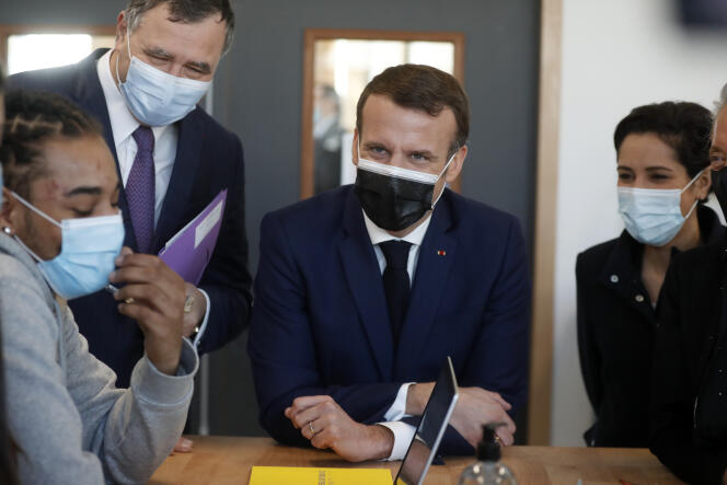 Emmanuel Macron aux côtés du PDG de Total, Patrick Pouyanne (à gauche), et de la ministre française de la jeunesse, Sarah El Hairy (à droite), écoutent une présentation des jeunes lors d’une visite à l’Industreet, à Stains, en Seine-Saint-Denis, le 1er mars 2021.