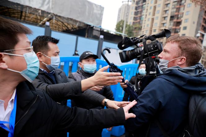 Des agents de sécurité bloquent un journaliste lors de la visite de Wuhan par des membres de l’Organisation mondiale de la santé, le 31 janvier.
