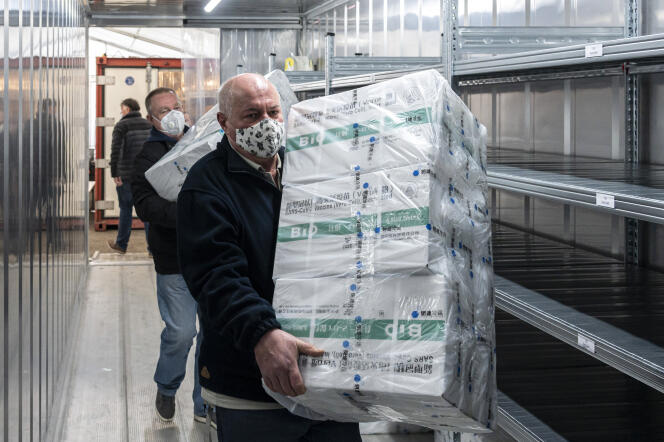 Des employés déchargent une livraison de vaccins chinois Sinopharm, sur une base logistique de Budapest, le 3 mars 2021.
