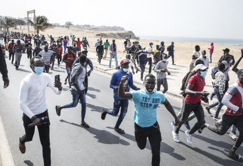 Supporters of Senegal's opposition leader Ousmane Sonko run down the road after word that their leader was arrested made its rounds in Dakar, on March 3, 2021. - Senegal's opposition leader Ousmane Sonko was arrested in Dakar on March 3, 2021, according to his lawyer, ahead of his scheduled court appearance to face a rape charge. Hundreds of supporters rallied in the city before the 46-year-old was due to appear before a judge for the charge, which he has claimed is politically motivated. (Photo by JOHN WESSELS / AFP)