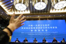 A journalist raises her hand to ask a question at the WHO-China Joint Study Press Conference held at the end of the World Health Organization mission in Wuhan, China, Tuesday, Feb. 9, 2021. (AP Photo/Ng Han Guan)