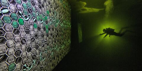 A diver uses a torch to explore artworks under the ice of the White Sea off the coast of the Republic of Karelia, Russia February 26, 2021. Paintings and sculptures by artist Denis Lotarev and works by photographer Viktor Lyagushkin are placed under the water and accessible to divers until the ice melts. Picture taken February 26, 2021. Courtesy of Viktor Lyagushkin/Handout via REUTERS ATTENTION EDITORS - THIS IMAGE WAS PROVIDED BY A THIRD PARTY. MANDATORY CREDIT TPX IMAGES OF THE DAY
