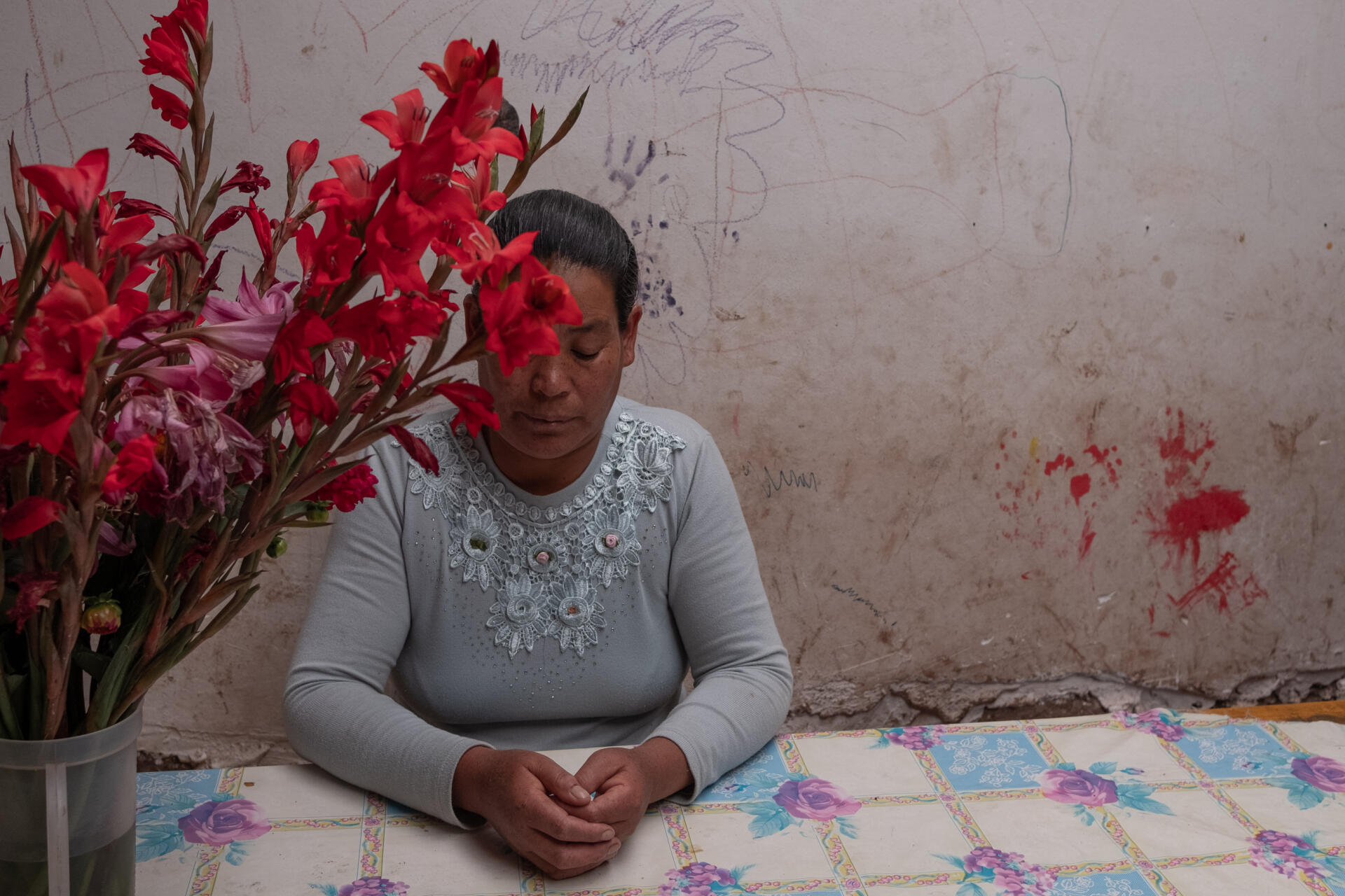 Aurelia, une femme quechua stérilisée, assise à la table de sa cuisine, après avoir témoigné, à Ancahuasi, Cusco (Pérou), le 7 mars.