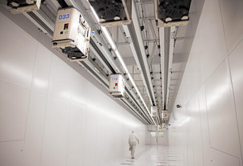 An employee passes beneath automated transport system cars carrying silicon wafer boxes in the clean rooms at the Globalfoundries semiconductor fabrication (fab) plant in Dresden, Germany, on Thursday, Feb. 11, 2021. The EU outlined a goal last year to produce at least one-fifth of the worlds chips and microprocessors by value, without giving details on how this would be achieved. Photographer: Liesa Johannssen-Koppitz/Bloomberg via Getty Images