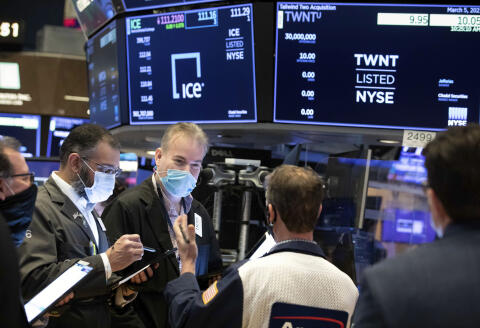 In this photo provided by the New York Stock Exchange, traders work on the floor, Friday, March 5, 2021, in New York. Stocks are swerving through another rocky ride Friday, as investors struggle to figure out what an encouraging report on the economy and the recent march higher for bond yields should mean for the market. (Nicole Pereira/New York Stock Exchange via AP)