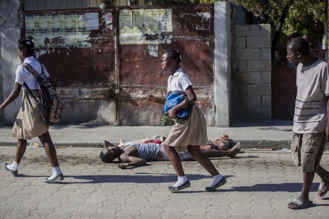 Des étudiants passent devant les corps de détenus, à l’extérieur de la prison civile de Croix-des-Bouquets, le 25 février à Port-au-Prince (Haïti).