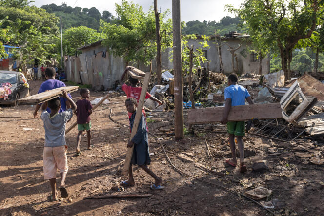 Des enfants récupèrent du bois dans les ruines du quartier Jamaïque, à Koungou (Mayotte), le 11 mars.