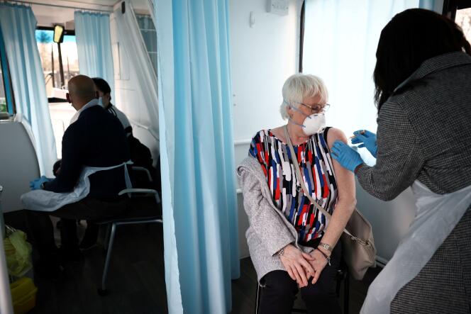 Administration du vaccin AstraZeneca dans un bus transformé en centre de vaccination mobile, à Londres, le 14 février.