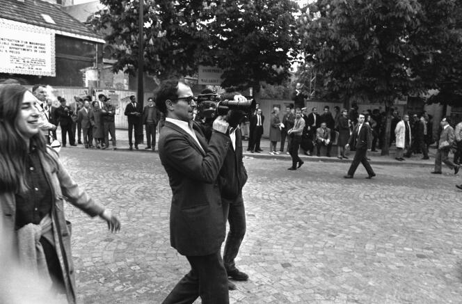 Jean-Luc Godard, caméra au poing, dans la manifestation des étudiants à Paris, le 13 mai 1968.