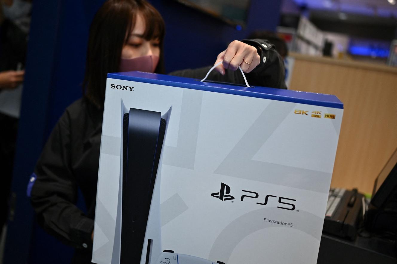 Sprzedawczyni ma kopię PlayStation 5 w dniu jej premiery w Japonii, w Kawasaki, 12 listopada 2020 r.