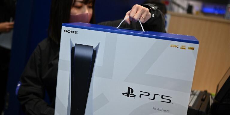 (FILES) In this file photo taken on November 12, 2020 An employee prepares the new Sony PlayStation 5 gaming console for a customer on the first day of its launch, at an electronics shop in Kawasaki, Kanagawa prefecture. 