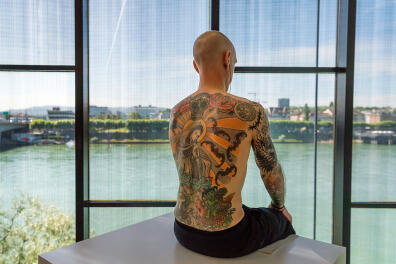 Tim Steiner poses with a tattoo by Belgian artist Wim Delvoye in the exhibition 'Wim Delvoye' at the Museum Tinguely in Basel, Switzerland, 13 June 2017. The retrospective of the artist's work opens to the public from 14 June 2017 to 01 January 2018.