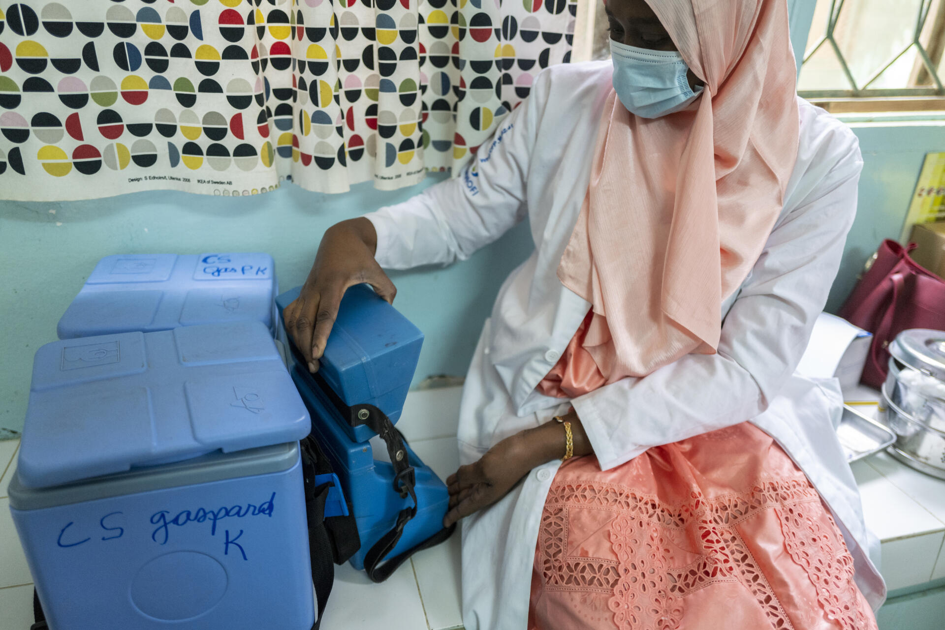 Une infirmière ouvre une petite glacière destinée à stocker les doses du vaccin chinois Sinopharm contre le Covid-19 à l’hôpital Gaspard-Camara de Dakar, le 5 mars 2021.
