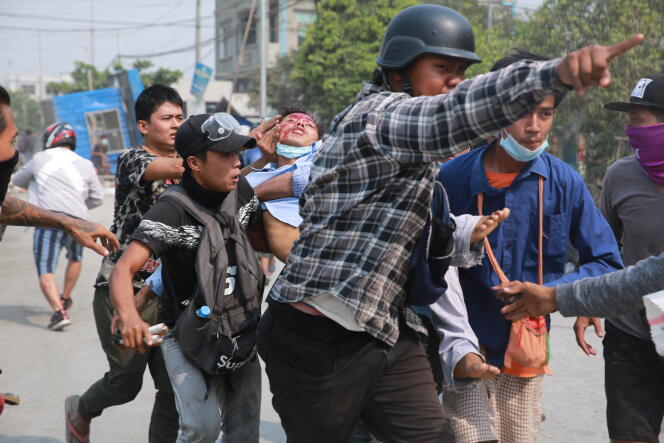 Des manifestants évacuent un blessé, lundi 22 mars, à Mandalay. Huit personnes ont été tuées, dimanche, par les forces armées dans la deuxième ville du pays.
