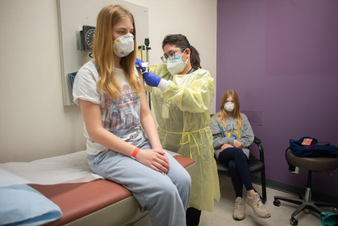 Isabelle King, 14 ans, reçoit sa deuxième dose du vaccin Moderna, sous le regard de sa sœur jumelle, Alexandra, à Houston (Texas), le 5 février.
