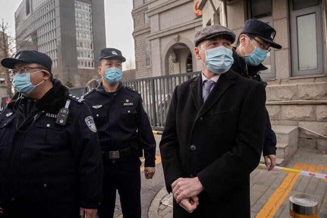 Des agents de police se tiennent à côté de Jim Nickel, le chargé d’affaires de l’ambassade du Canada à Pékin, devant le deuxième tribunal populaire intermédiaire de Pékin, le 22 mars 2021, lors du procès de Michael Kovrig.