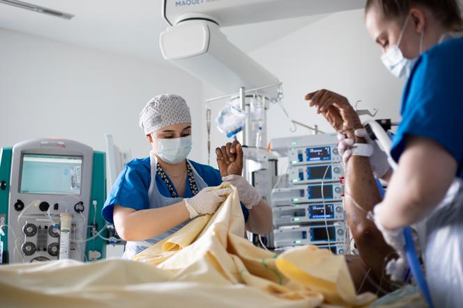 Une infirmière et une aide-soignante massent un patient au service de réanimation chirurgicale de l’hôpital Henri-Mondor, à Créteil, le 22 mars 2021.