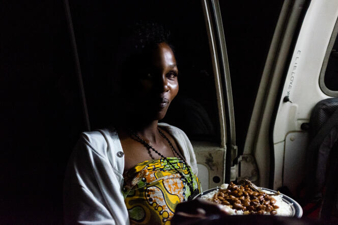 Clara (son prénom a été changé), une adolescente qui vit de la prostitution, récupère son repas auprès de la clinique mobile, à Kinshasa.