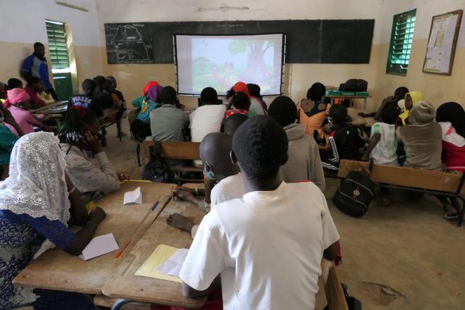 Projection d’un film de sensibilisation à la nature dans une classe de l’école du village de Djilasse, animée par Ndiawar Faye (debout, à gauche) de Nébéday, dans le Sine Saloum, au Sénégal, en mars 2021.