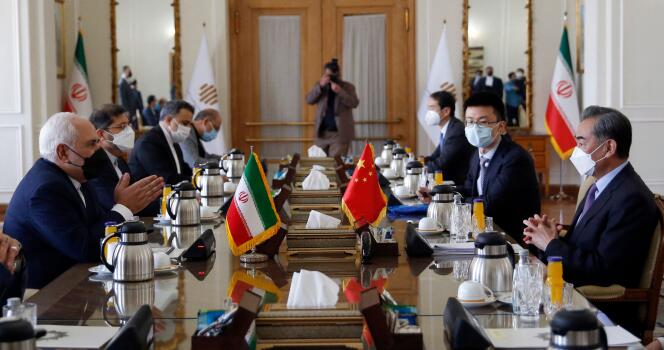 Le ministre iranien des affaires étrangères, Mohammad Javad Zarif (à gauche) lors d’une rencontre avec son homologue chinois, Wang Yi (à droite), le 27 mars 2021 à Téhéran. Les deux pays avaient ce jour-là signé un accord de coopération stratégique sur vingt-cinq ans.