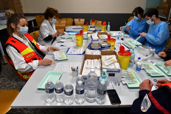 Caregivers are preparing doses of Pfizer-BioNTech vaccines at the Toulouse Exhibition Center on March 27, 2021.