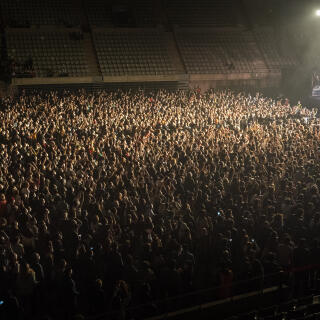 People attend a music concert in Barcelona, Spain, Saturday, March 27, 2021. Five thousand music lovers are set to attend a rock concert in Barcelona on Saturday after passing a same-day COVID-19 screening to test its effectiveness in preventing outbreaks of the virus at large cultural events. The show by Spanish rock group Love of Lesbian has the special permission of Spanish health authorities. While the rest of the country is limited to gatherings of no more than four people in closed spaces, the concertgoers will be able to mix freely while wearing face masks. (AP Photo/Emilio Morenatti)