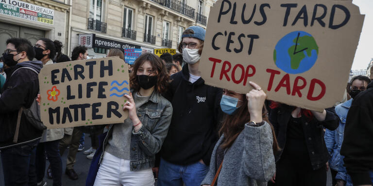 Youths hold placards during a rally against the climate change in Paris, Sunday, March 28, 2021. Thousands of people took to the streets in Paris and other French cities asking for tougher climate law. (AP Photo/Michel Euler)