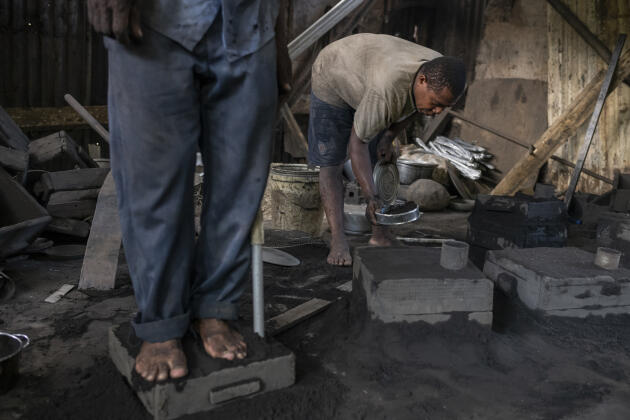 Des hommes fabriquent des ustensiles de cuisine en fondant du métal dans le bidonville de Kaweni, le 5 décembre 2020. Les activités informelles sont le principal revenu des habitants du bidonville.