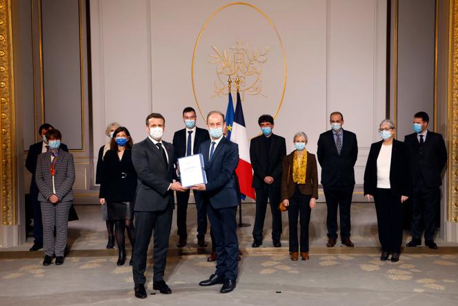 Vincent Duclert (droite) remet son rapport sur le rôle de la France dans le génocide rwandais à Emmanuel Macron, à l’Elysée, à Paris, le 26 mars.