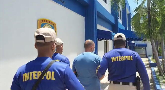 Des agents d’Interpol escortent Marc Feren Claude Biart, à Boca Chica, en République dominicaine, le 24 mars.