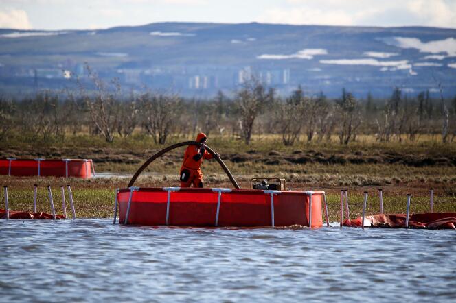 Un agent du ministère russe des urgences intervient dans une rivière après une fuite de pétrole provenant d’un site minier, en juin 2020.