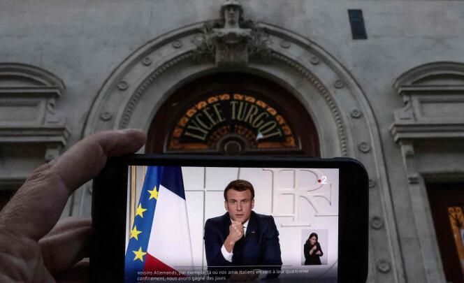 L’allocution d’Emmanuel Macron le 31 mars, retransmise sur un smartphone devant le lycée Turgot à Paris.