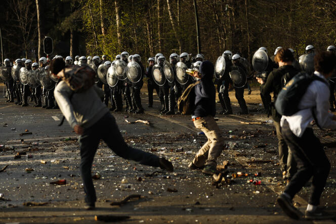 Des manifestants jettent des pierres et des bouteilles contre la police le 1er avril au bois de la Cambre, à Bruxelles.