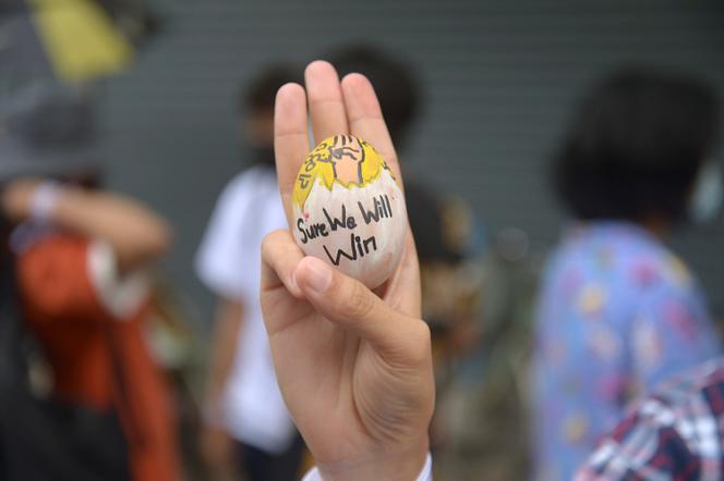 Un manifestant soulève un œuf de Pâques, décoré avec le symbole de résistance à trois doigts, lors d’une manifestation contre le coup d’Etat militaire le dimanche de Pâques, le 4 avril à Yangon.