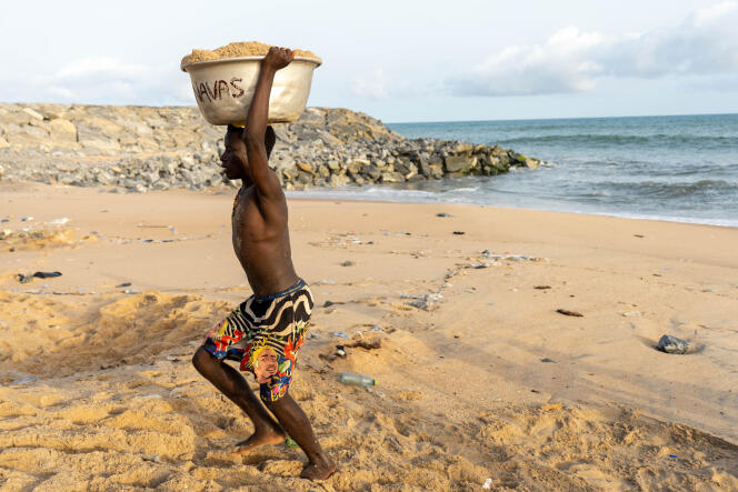 Un adolescent achemine du sable extrait illégalement de la plage d’Elmina, au Ghana, le 26 mars 2021. Le seau de sable sera vendu pour fabriquer des parpaings.