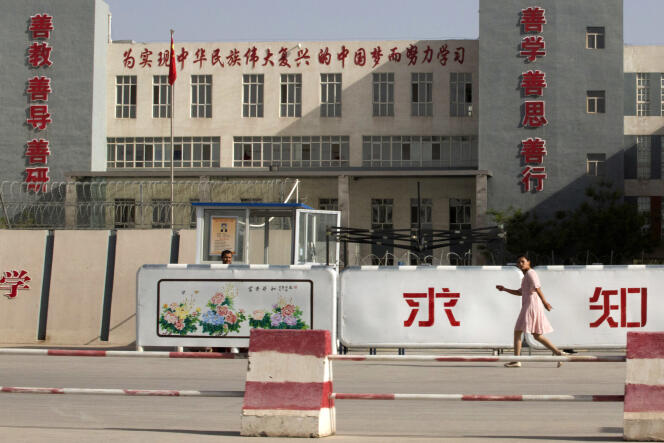 Le 31 août 2018, une femme passe devant un bâtiment présenté comme une école, dans la préfecture de Kashgar, au Xinjiang, dans l’ouest de la Chine. Pékin a déclaré avoir condamné à mort deux anciens responsables de la région, y compris l’ancien chef du département de l’éducation, pour séparatisme et corruption.