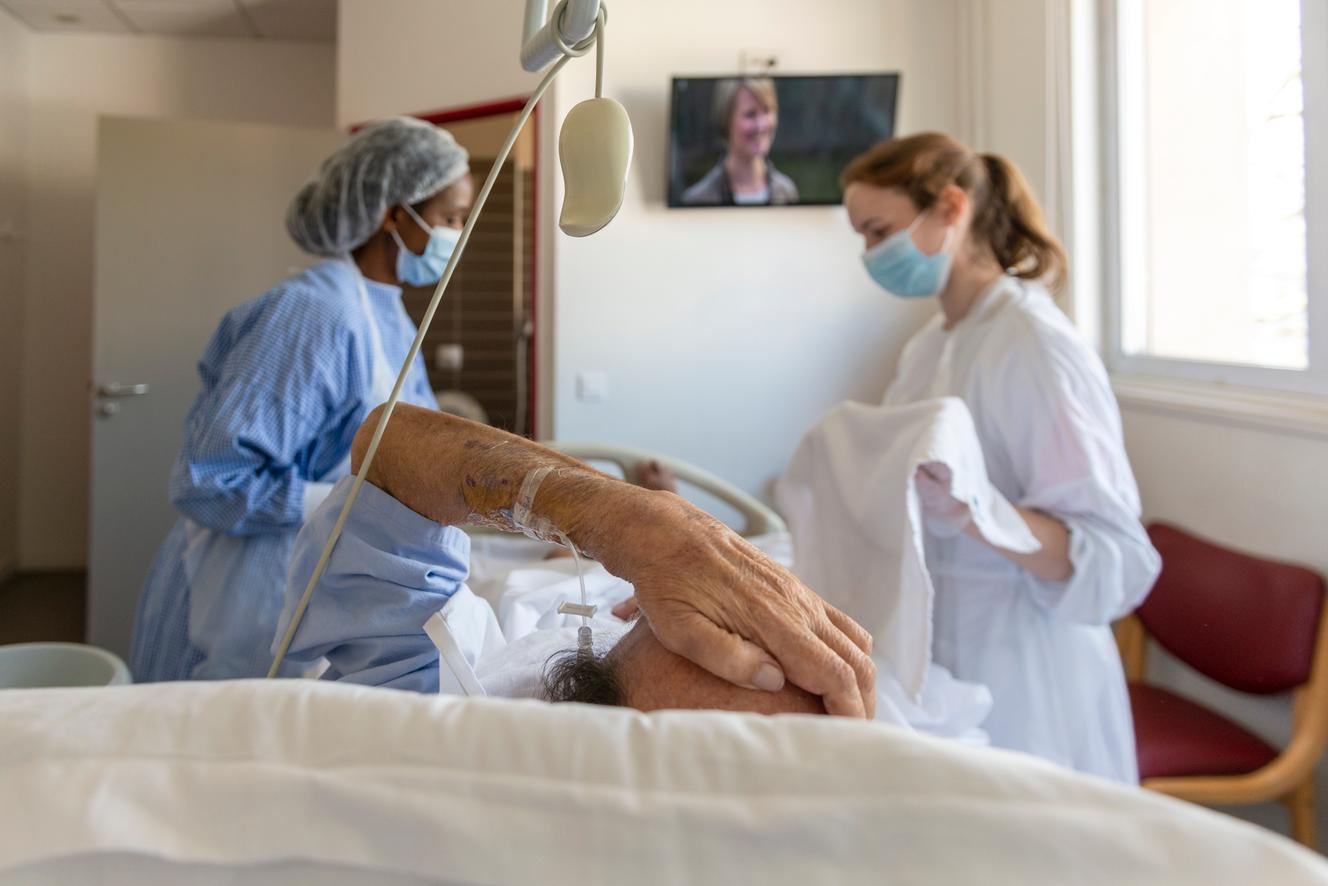 Une infrmière et une aide-soignante travaillent en binôme pour réaliser la toilette d'un patient en soins palliatifs au centre hospitalier Rives-de-Seine, à Puteaux (Hauts-de-Seine).