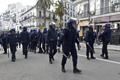 Riot police position themselves in a street during an anti-government protest in the capital Algiers on March 9, 2021. (Photo by RYAD KRAMDI / AFP)