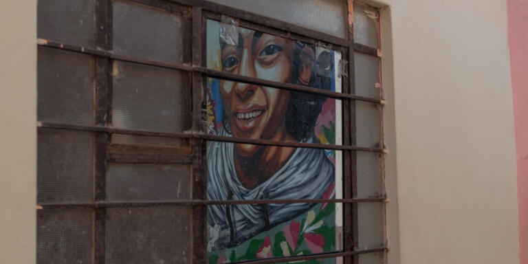  14_8 avril 2021, Centre Historique Lima, Pérou
Dans une fenêtre du quartier de la famille Sotelo, se reflète la peinture murale du visage de Into Sotelo, jeune décédé pendant les manifestations en novembre 2020.