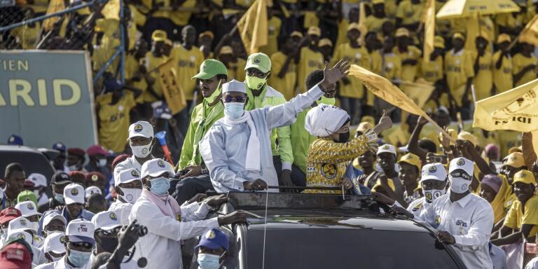 Chadian President Idriss Deby Itno (C-L), flanked by his wife Amani Hilal (C-R), waves as he arrives to attend his election campaign rally in N'djamena on April 9, 2021. Chad's citizens are set to go to the polls for the first round of the Presidential election on April 11, 2021.  / AFP / MARCO LONGARI
