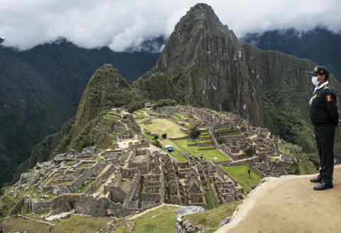 A tourist policeman is seen on duty at the archaeological site of Machu Picchu, in Cusco, Peru during its reopening on November 01, 2020, amid the new coronavirus pandemic. - The Inca citadel of Machu Picchu reopened on Sunday in the framework of a gradual decrease in COVID-19 contagions in Peru, after remaining empty almost eight months, affecting the tourism sector severely. (Photo by ERNESTO BENAVIDES / AFP)