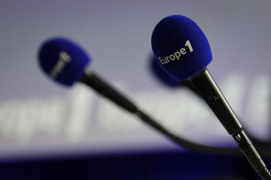 A picture taken on December 20, 2018 shows microphones with the Europe 1 logo during the Europe 1 morning radio show "Deux heures d'info" in the "Pierre Bellemare" new studio, in Paris. (Photo by Thomas SAMSON / AFP)