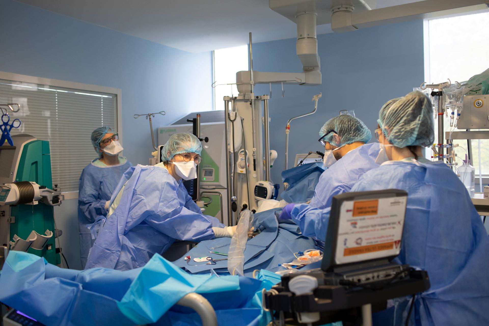 Une interne change un cathéter, permettant d’administrer les différents produits à un patient malade du Covid-19. Service de réanimation de l’hôpital Bichat, à Paris, le 9 avril 2021.