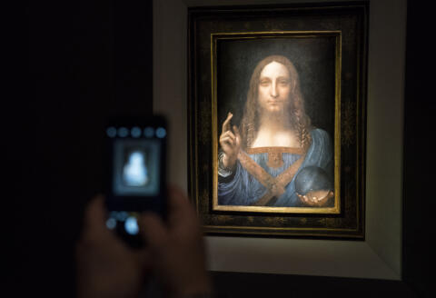NEW YORK, NY - NOVEMBER 15: A visitor takes a photo of the painting 'Salvator Mundi' by Leonardo da Vinci at Christie's New York Auction House, November 15, 2017 in New York City. The coveted painting is set to be auctioned off on Wednesday night and has been guaranteed to sell for over $100 million.(Drew Angerer/Getty Images) (Photo by Drew Angerer / GETTY IMAGES NORTH AMERICA / Getty Images via AFP)
