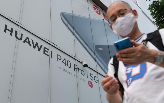 Un piéton passe devant un panneau publicitaire de Huawei, à Tokyo, le 26 juin 2020.