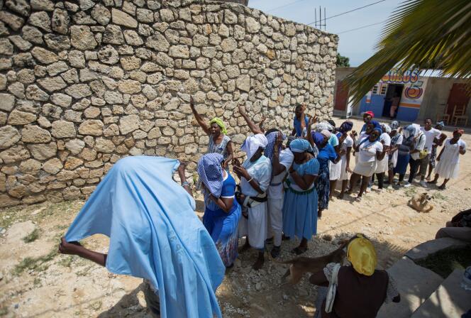 Des fidèles prient pour la libération des religieux enlevés la veille, près de l’église Saint-Roch à Port-au-Prince, le 12 avril.