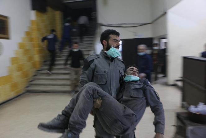 Un homme syrien, membre de la défense civile, transporte un homme touché par un gaz chimique à l’hôpital de campagne, après l’attaque présumée au chlore dans la Ghouta orientale à Damas, le 6 mars 2018.