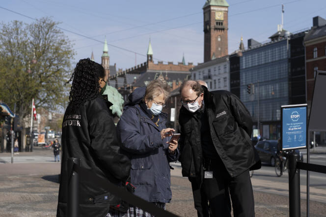 A l’entrée du musée Glyptotek, à Copenhague, des employés vérifient le « Coronapas » de Inge Horup, une retraitée venue le visiter, le 21 avril.
